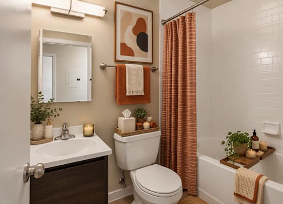 A bathroom with a toilet, sink, and a shower curtain.