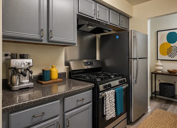 A modern kitchen with a black fridge and stove.