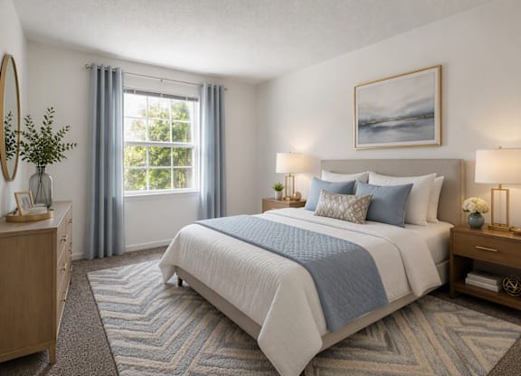 A bedroom with a large bed and a window with curtains.
