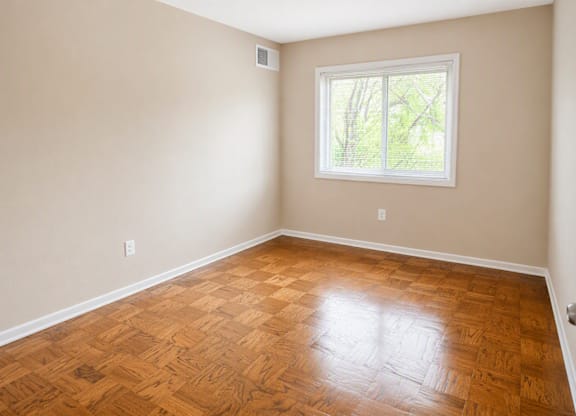 A room with a wooden floor and a window.