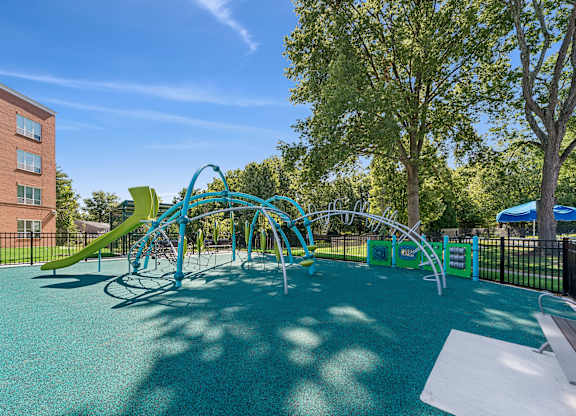 A playground with a blue slide and a green slide.