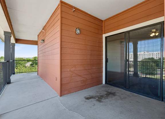A wooden building with a glass door and a black gate.