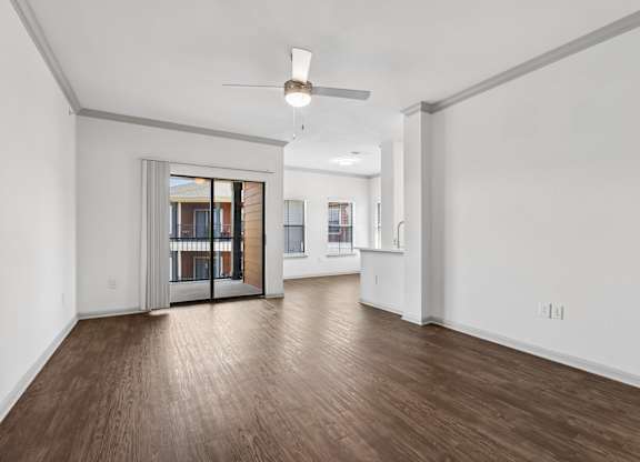 A room with wooden floors and a ceiling fan.