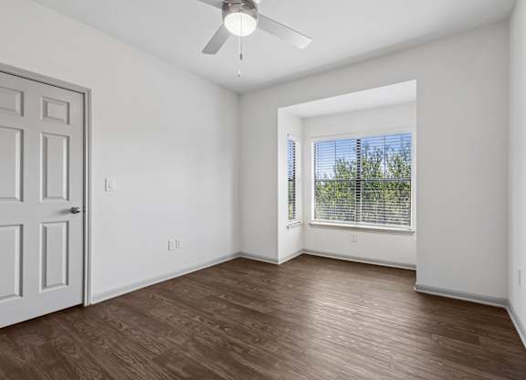 A room with a ceiling fan and a door.