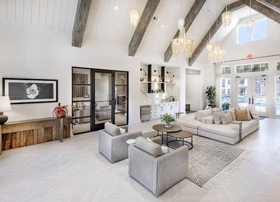 A spacious living room with a high ceiling and a large window at Folksong Apartments, Flowery Branch