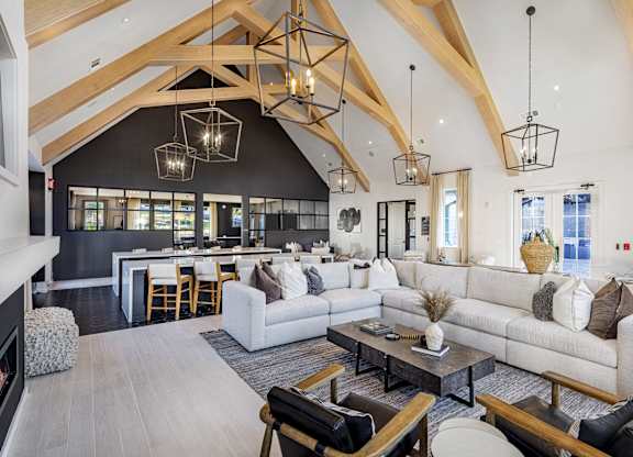 A modern living room with a high ceiling and wooden beams at Folksong Apartments, Flowery Branch, 30542