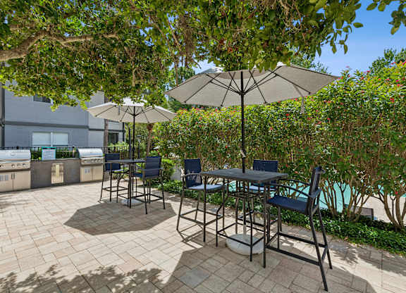 A patio with a table and chairs under umbrellas.