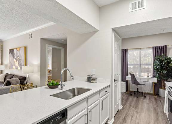 A modern kitchen with a white countertop and stainless steel appliances.