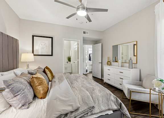 A bedroom with a bed, dresser, and mirror.