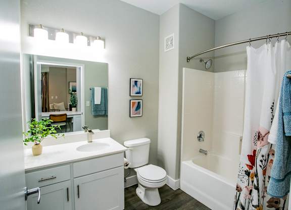 A white bathroom with a toilet, sink, and bathtub. at Octave Apartments, Las Vegas, NV, 89123