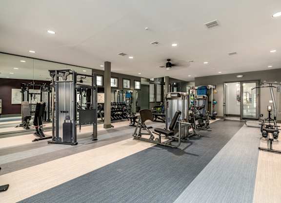 A spacious gym with a variety of equipment.