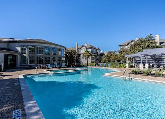 A large swimming pool in front of a house.