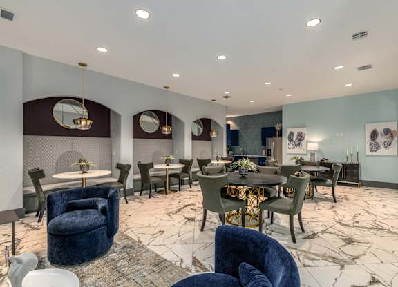 A room with a dining table surrounded by chairs.