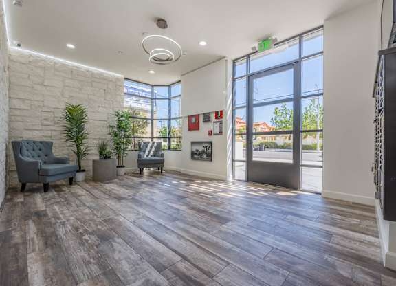 A room with a grey sofa and a wooden floor.