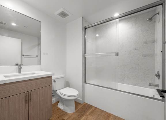 A bathroom with a toilet, sink, and shower.
