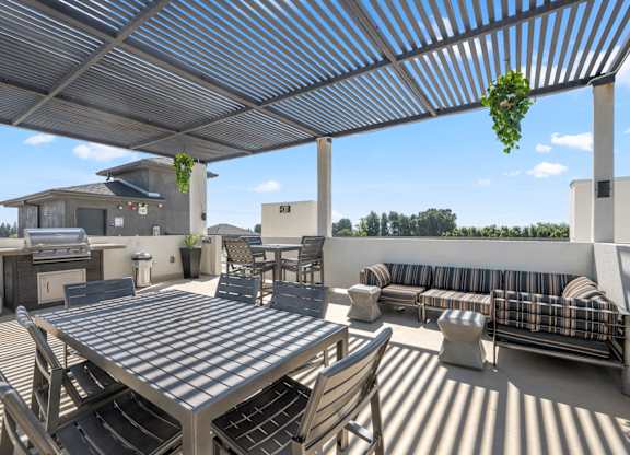 A patio with a table and chairs under a roof.