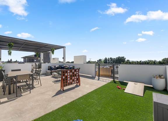 A patio with a table and chairs under a pergola.