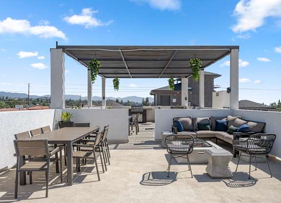 A patio with a table and chairs under a roof.