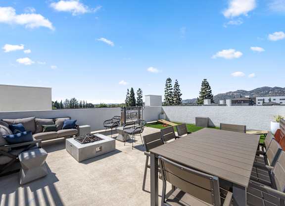 A patio with a table and chairs is set up on a sunny day.