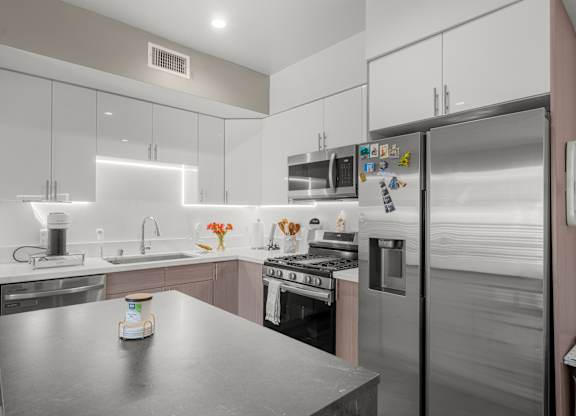 A modern kitchen with stainless steel appliances and a central island.