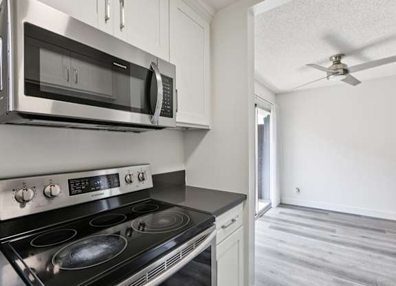 A modern kitchen with a stainless steel stove and microwave.