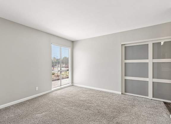 A room with a carpeted floor and a sliding glass door.