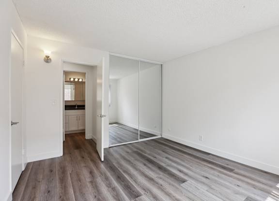 A room with a white wall and a wooden floor.