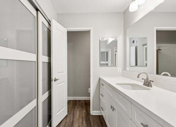 A bathroom with a white sink and a white door.