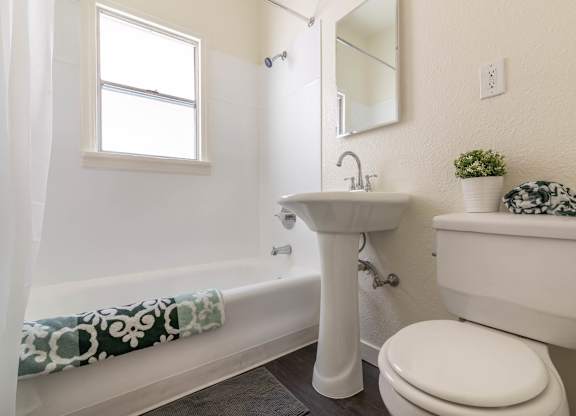 A white bathroom with a toilet, sink, and bathtub.