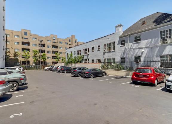 A parking lot with cars and buildings in the background.