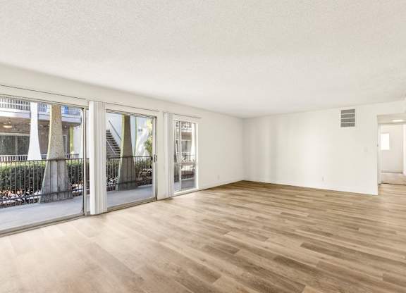 A room with wooden flooring and white walls.