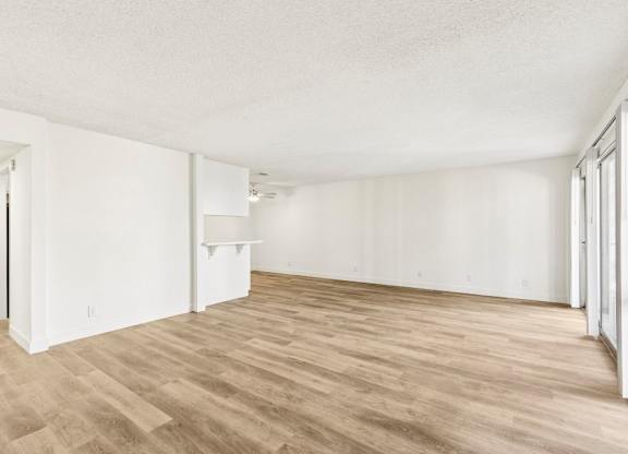 A room with wooden flooring and white walls.