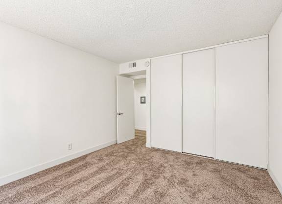 A room with a carpeted floor and white walls.