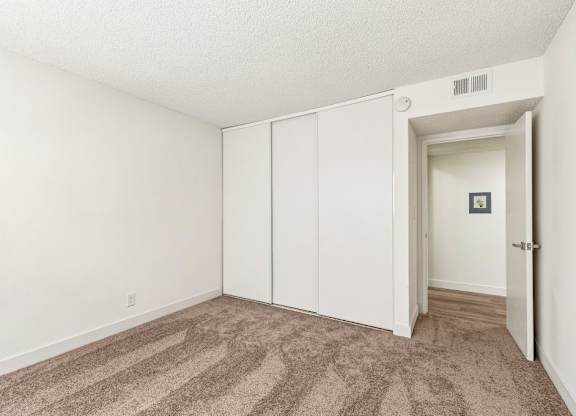A room with a carpeted floor and a white door.