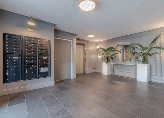 A spacious room with a grey floor and a black cabinet on the wall.