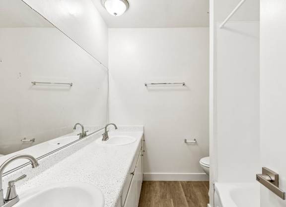 A white bathroom with a sink and toilet.