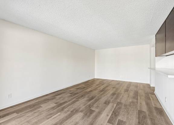 A room with wooden flooring and white walls.