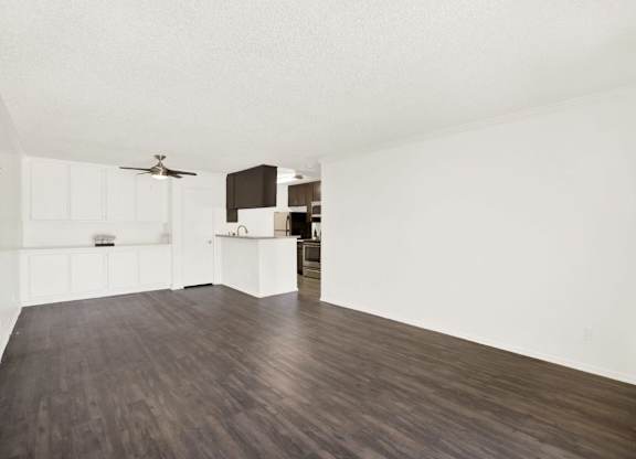 A room with a ceiling fan and a kitchen area at Monterra Ridge Apartments, Canyon Country, California