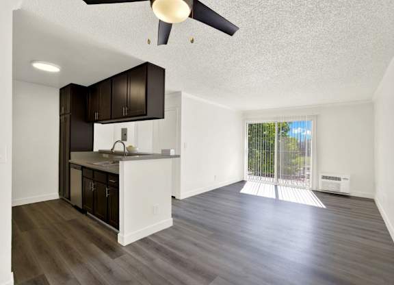 A kitchen with dark brown cabinets and a white countertop at Monterra Ridge Apartments, Canyon Country