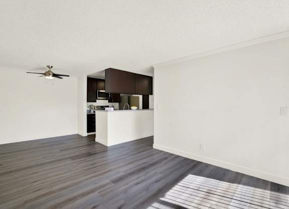 A room with a ceiling fan and a kitchen area at Monterra Ridge Apartments, Canyon Country, California