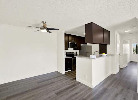 A modern kitchen with dark wood cabinets and a white island at Monterra Ridge Apartments, Canyon Country, 91351