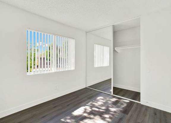 A room with a white wall and a wooden floor at Monterra Ridge Apartments, Canyon Country