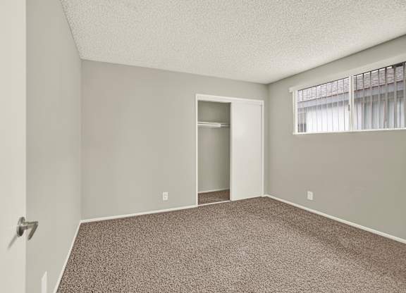 A room with a carpeted floor and a doorway leading to another room at The Square in Downey, CA, 90242