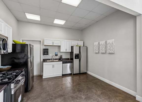 A kitchen with black appliances and white cabinets.