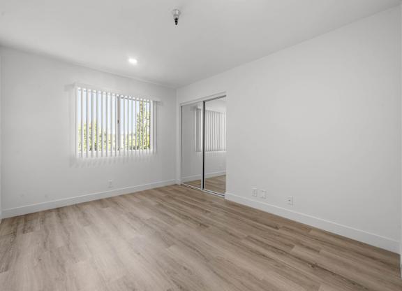 A room with a sliding door and a window with blinds.