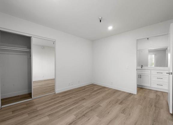 A room with a sliding door and wooden flooring.