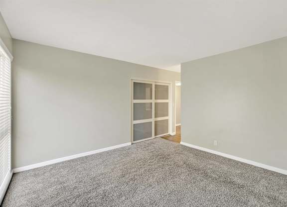 Empty bedroom with frosted glass sliding doors at Parc @ 5 Apartments, Downey, CA 90240