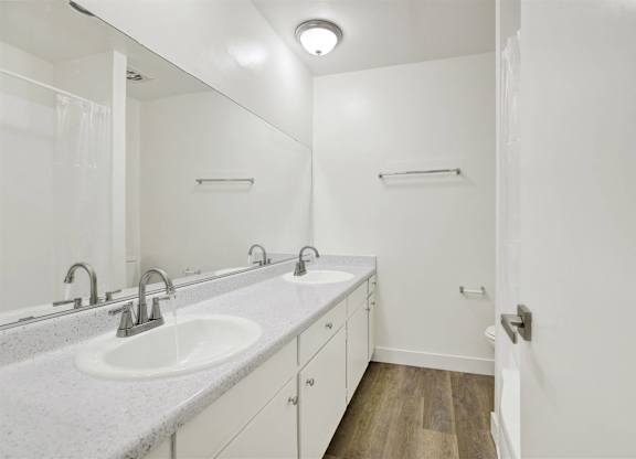 Bathroom with double vanity and large mirror at Parc @ 5 Apartments, Downey, CA 90240