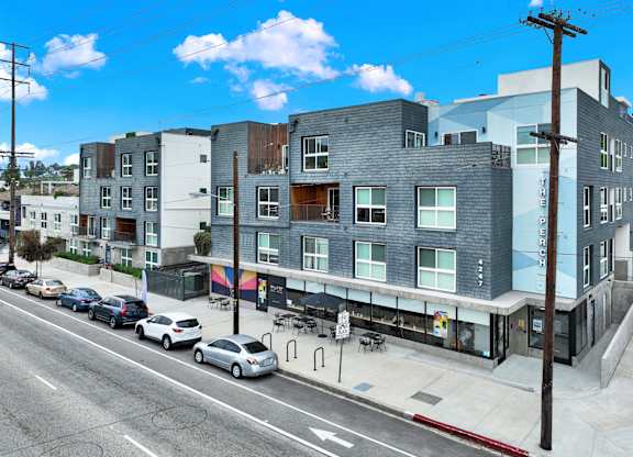 an apartment building on a city street with cars at the perch, Los Angeles California