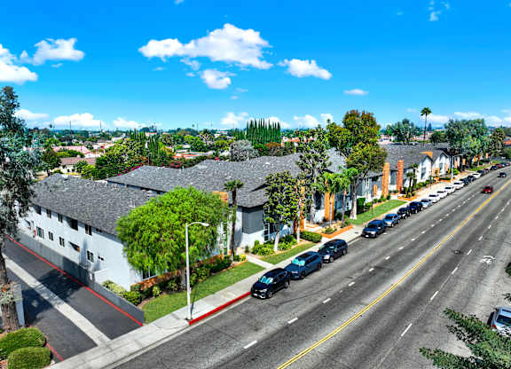 A street view of a residential area with cars parked on the side of the road at The Square in Downey, CA, 90242